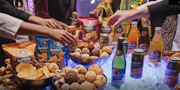 People reaching for Bushfaller snacks and drinks at a lively gathering.