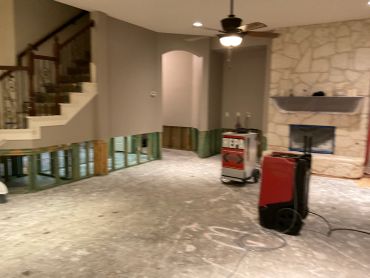 Room under renovation with removed flooring and exposed lower walls.