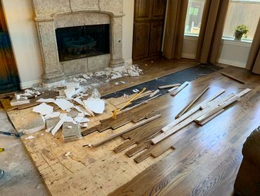 Living room floor with damaged and removed wooden planks.