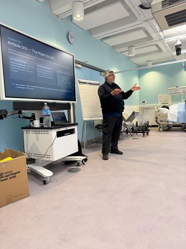 Man giving a presentation in a medical or educational room.
