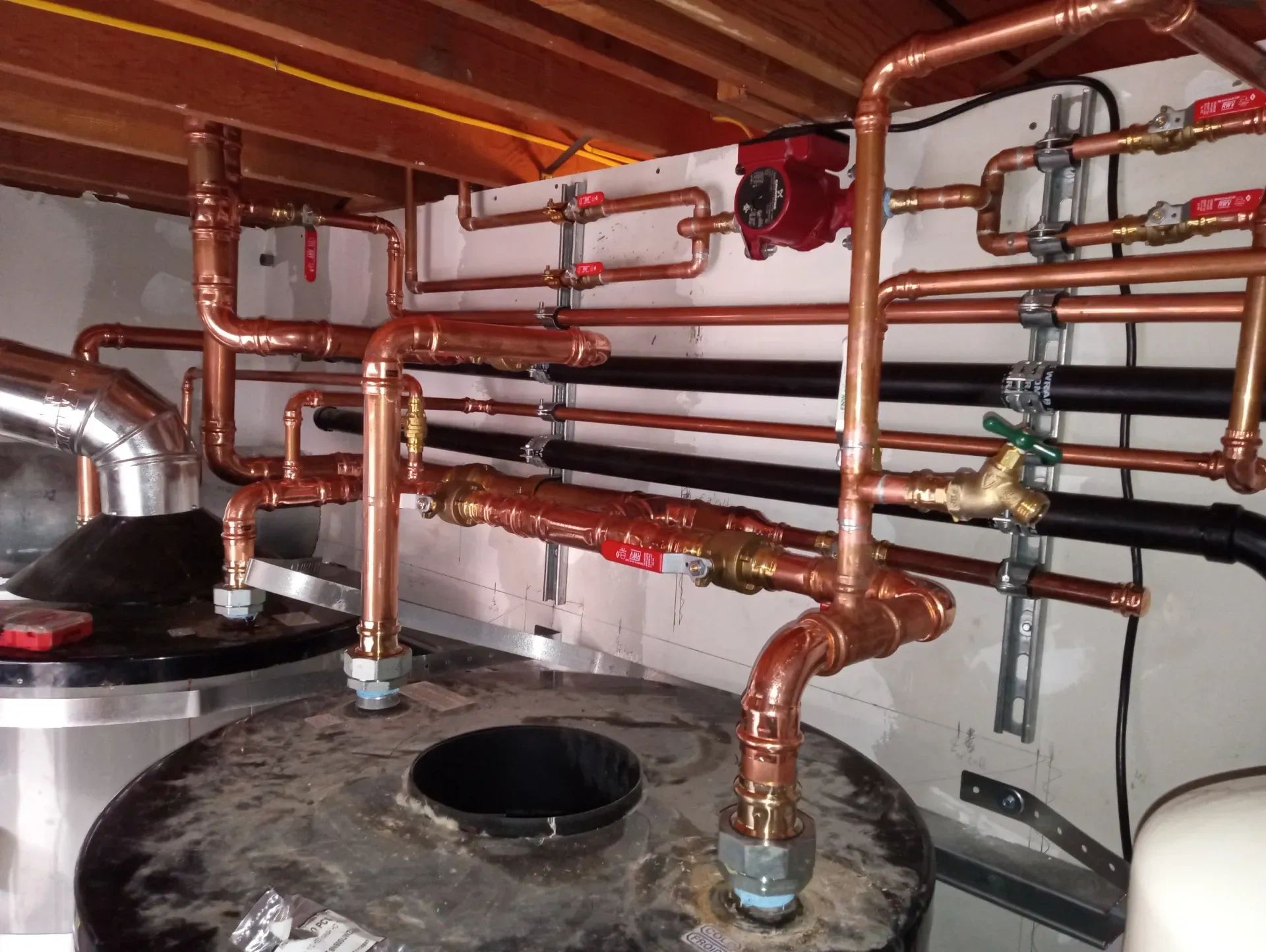 Copper plumbing pipes with valves and fittings in a mechanical room in Morgan Hill.