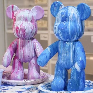 Two bear-shaped sculptures with marbled paint in pink and blue.