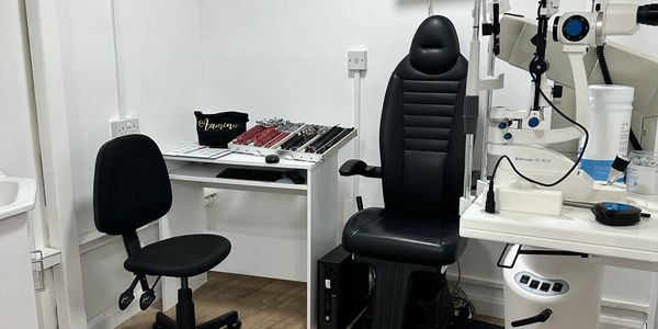 An optometrist exam room with chairs and equipment.