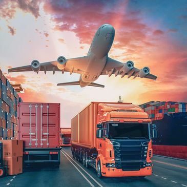 Cargo truck on road with airplane flying overhead at sunset.