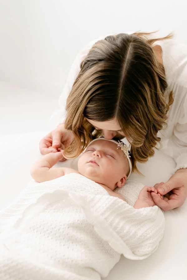 mom kissing newborn baby head