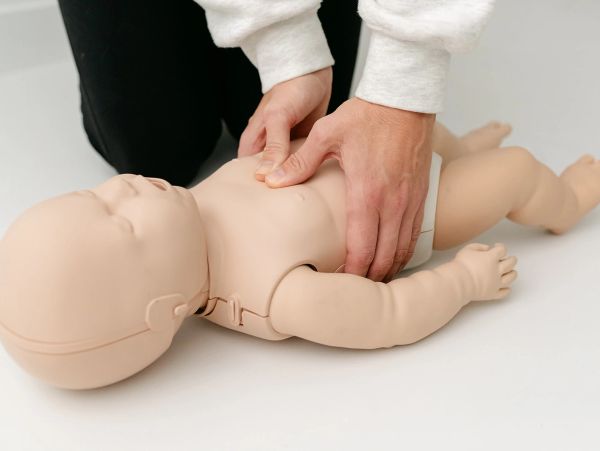 baby manikin getting chest compressions for CPR