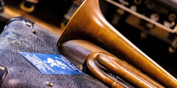 Trumpet and Business card sit atop a dusty vintage Guitar Amplifier