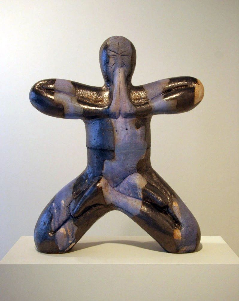 Nearly life-sized ceramic sculpture of a genuflecting monk.