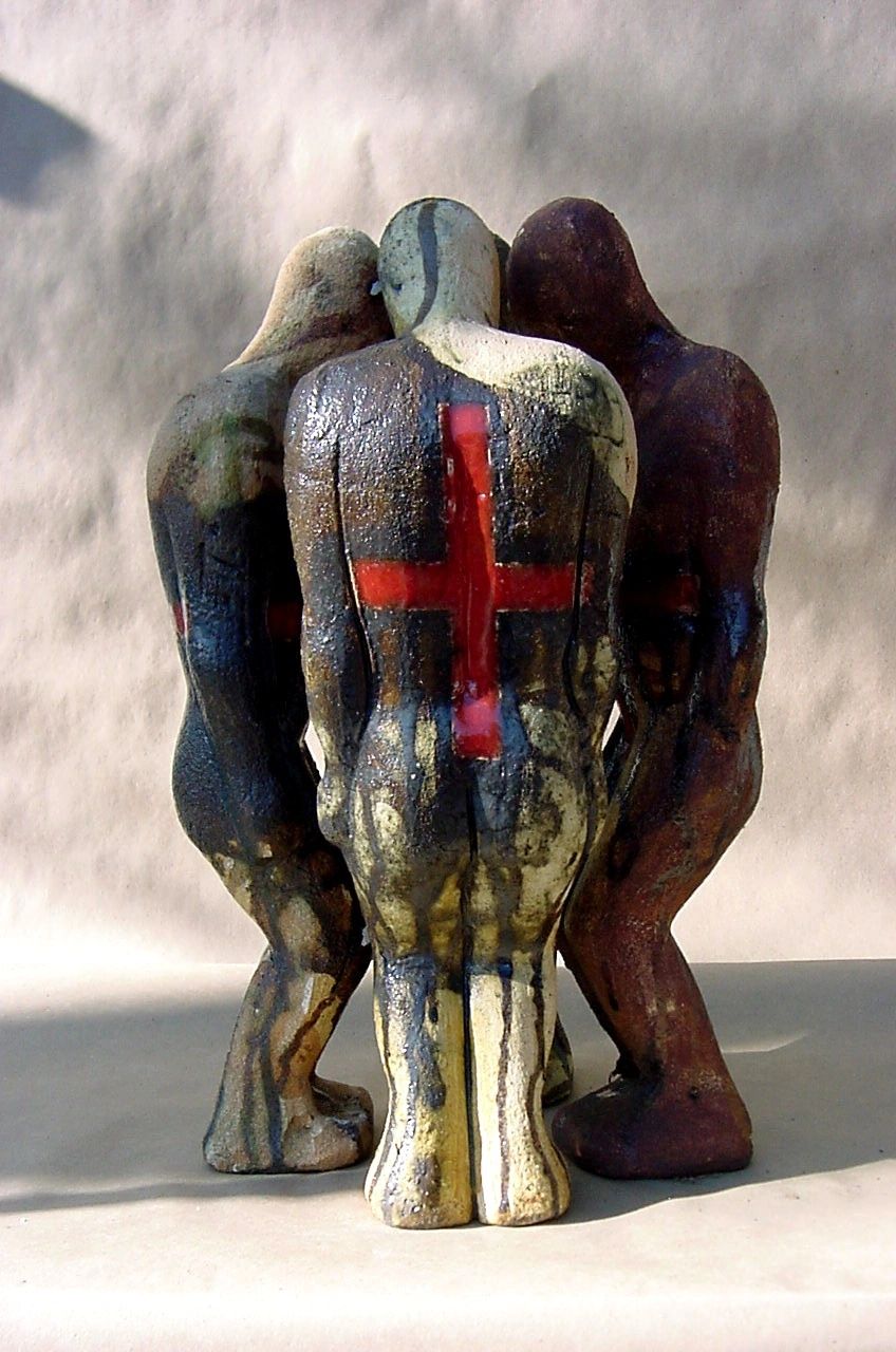 Four small figurative ceramic sculpture huddled together creating an abstract form.