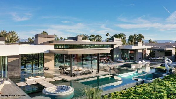 Modern luxury house with large glass windows and a swimming pool.