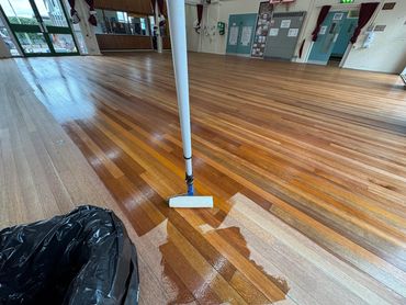 Primer coat being rolled onto a freshly sanded Keruing Hardwood Strip floor in a school
