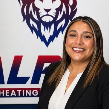 Professional woman smiling in front of a company logo.