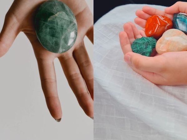 Hands holding and surrounded by various colorful healing crystals and stones.
