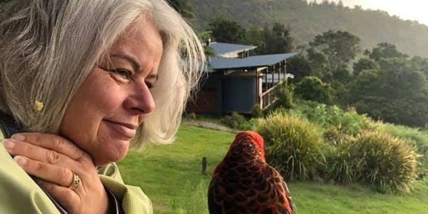Woman looking at a bird outdoors.