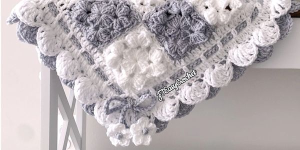 Beautiful grey and white baby  blanket with bow ties in the corners