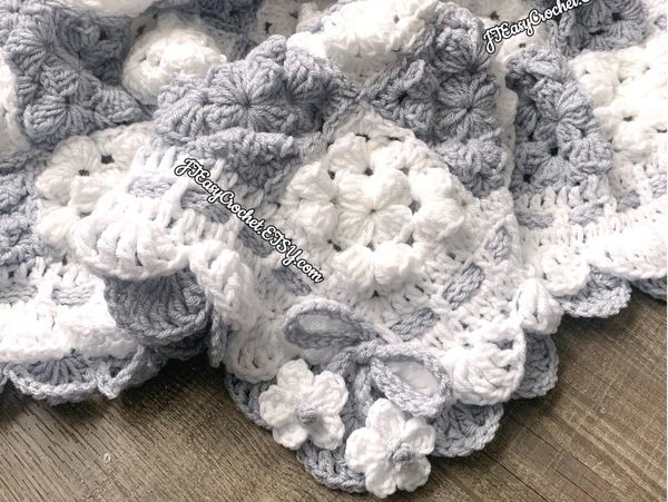 Beautiful ruffled baby blanket made with granny squares with ties and flowers, grey and white 