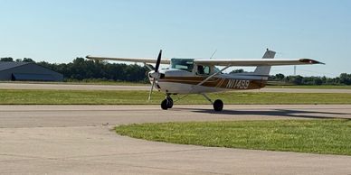 Small single-engine airplane taxiing on runway.