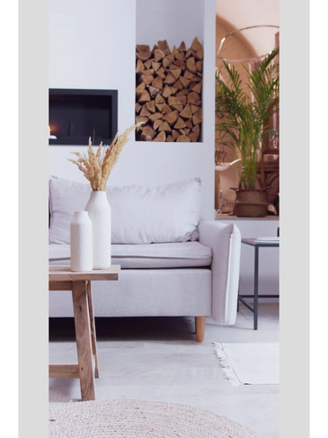 Cozy living room with beige sofa, wooden table, and firewood stack.