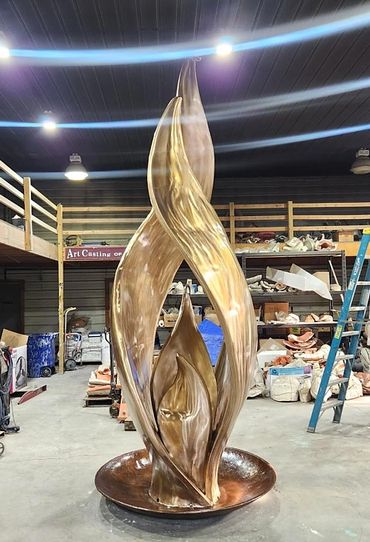 A large abstract Eternal flame shaped bronze sculpture in an Art Bronze Foundry. Veteran's Memorial