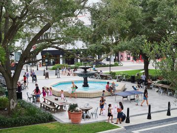 Amenities Page. Fountain in Hyde Park Village, Tampa, FL. People partaking in a variety of activity.
