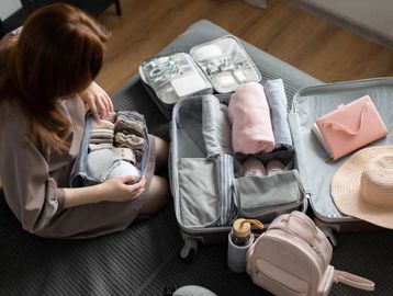 Amenities Page. A woman packing luggage on her bed.