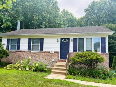 Small suburban house with a dark front door and blue shutters.