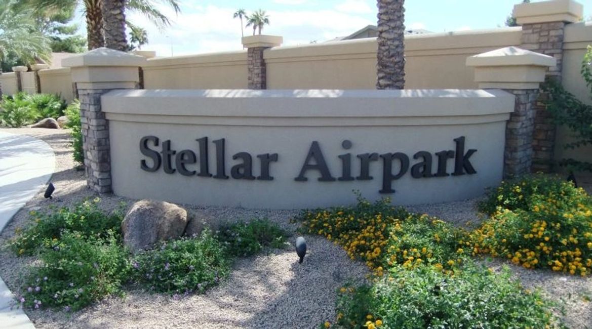 Sign in front of Stellar Airpark in Chandler, Arizona with flowers in front of it and a wall behind.