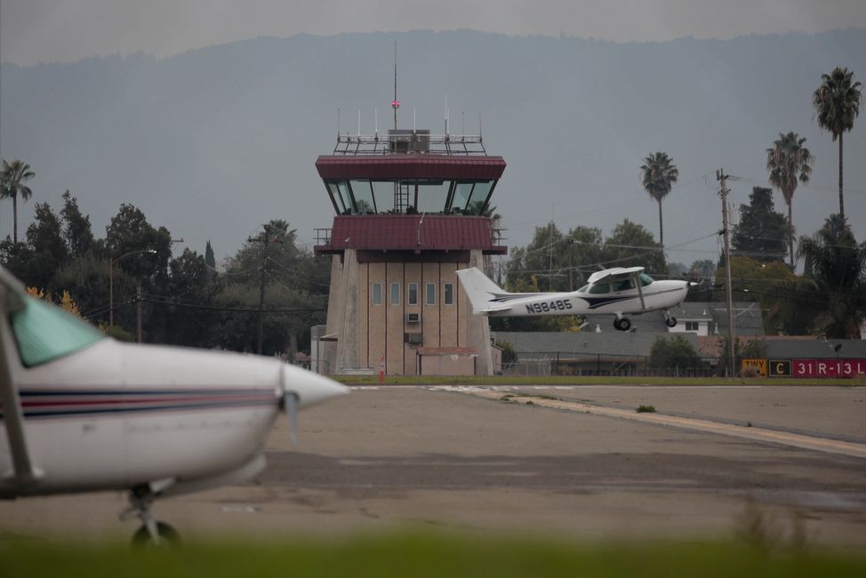 FAA Air Traffic Control Tower at Reid-Hillview Airport in San Jose, CA with two airplanes in front.