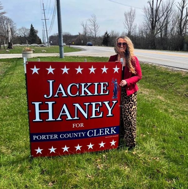 A woman stands beside a political sign for Jackie Haney, Porter County Clerk.