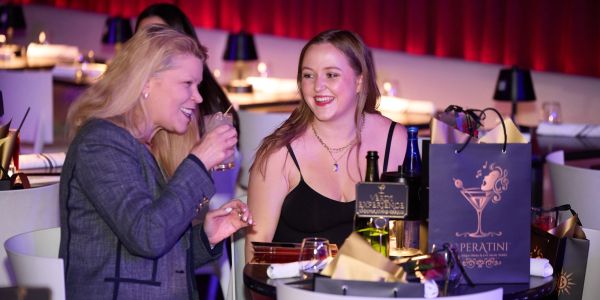 Two women enjoying drinks and conversation at a bar.