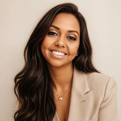 Smiling woman with long dark hair wearing a beige blazer.