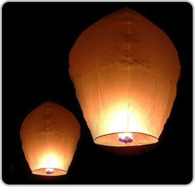 Two glowing sky lanterns floating in the night sky.