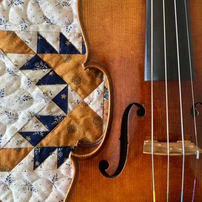 Violin in front of a quilt