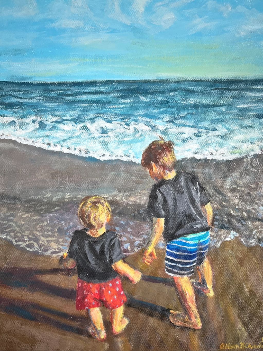 Two boys approaching edge of ocean.