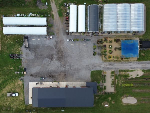 Aerial view of farm greenhouses and a building.