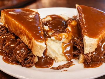 Open roast beef sandwich with mashed potatoes and rich brown gravy.
