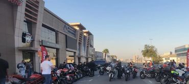 A large group of Ducati motorcycles parked on a street at sunset.