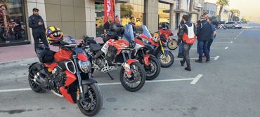 Ducati Motorcycles parked on a street with people nearby.