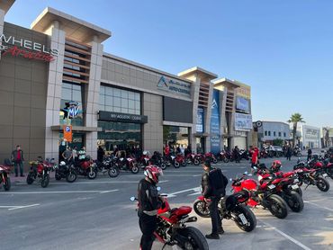 Motorcycle gathering outside a showroom.