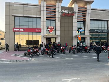 Motorcycles parked outside a showroom with Ducati and MV Agusta logos.