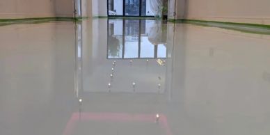 A shiny, polished floor reflecting the room's entrance and ceiling lights.