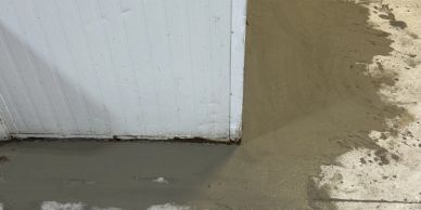 Fresh cement applied around a wall corner.
