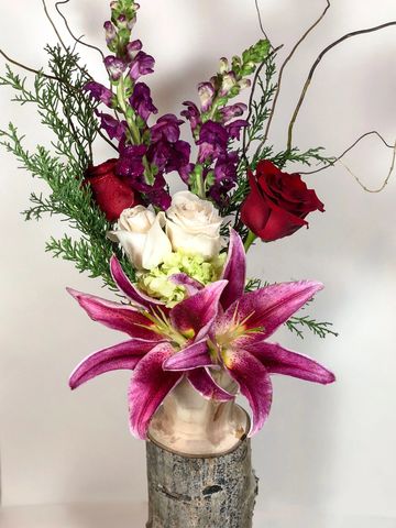 Elegant floral arrangement with vibrant pink lilies and roses.