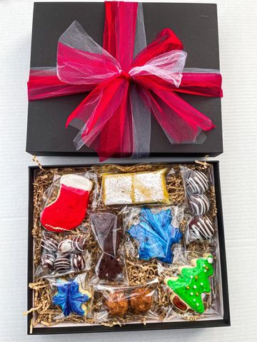 Holiday gift box with decorated cookies and chocolates.