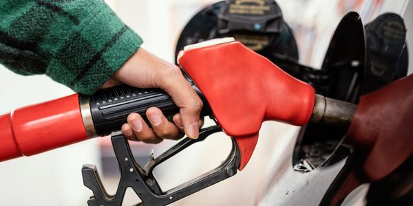 Man at gas station with a red petrol pump