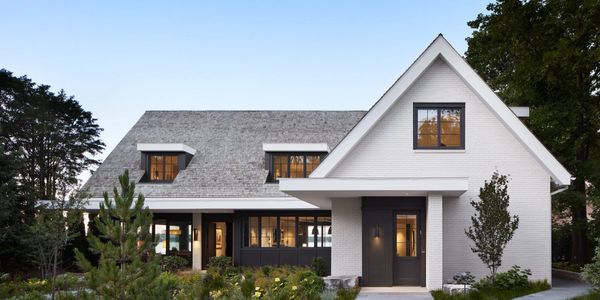 Modern white house with large porch and dark window frames.