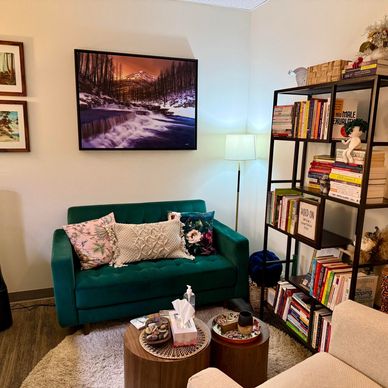 Cozy living room with green sofa, bookshelves, and warm lighting.