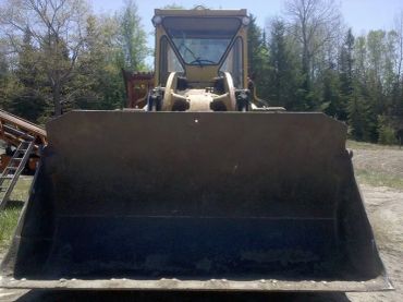 Front view of a bulldozer bucket in a rural area.