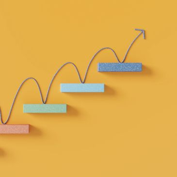Colorful blocks connected by a zigzag line forming an upward arrow on a yellow background.
