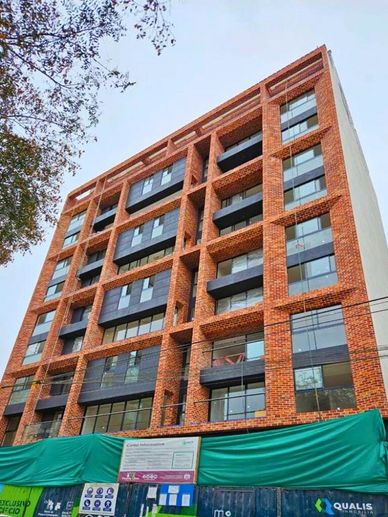 Edificio moderno de ladrillo en construcción con ventanas grandes.